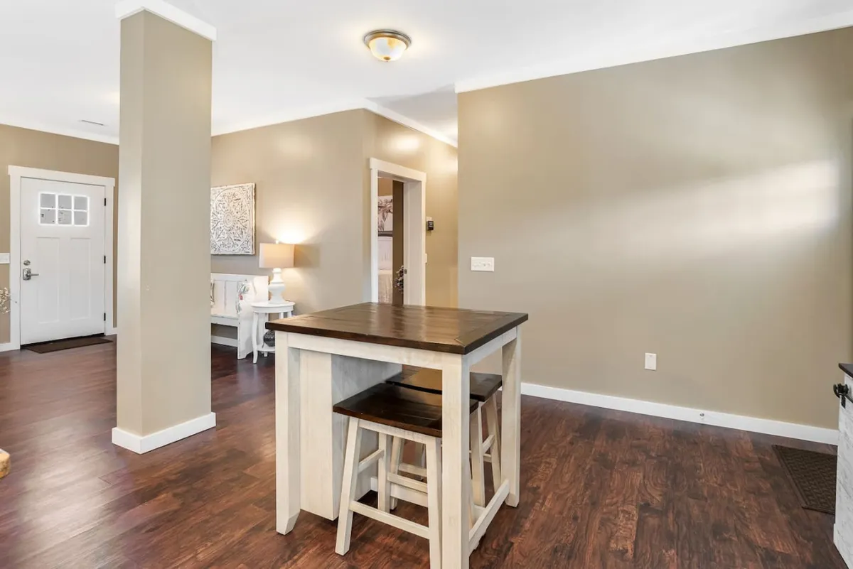 A welcoming kitchen view that includes the island, front door, and a modern lighting fixture overhead. This perspective highlights the kitchen's integration with adjoining spaces and its proximity to the home’s entrance, suggesting seamless flow for entertaining guests and staying connected during meal prep.